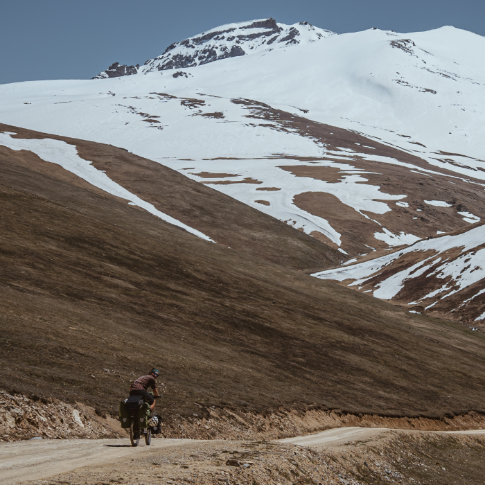  Mountain biking,  Radfahrer,  Schotterstraße,  schneebedeckte Berge,  Rucksack